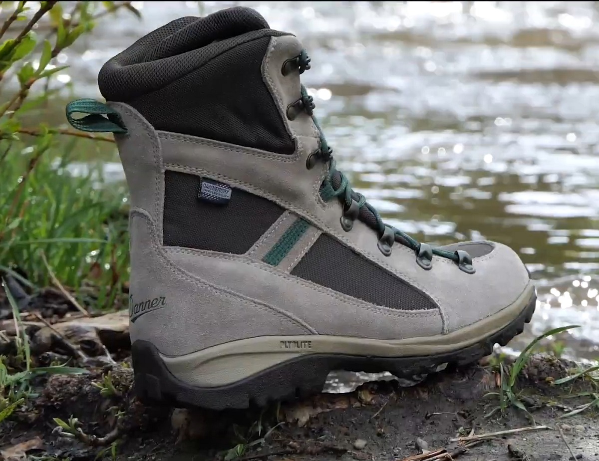 A single waterproof hunting boot beside a river