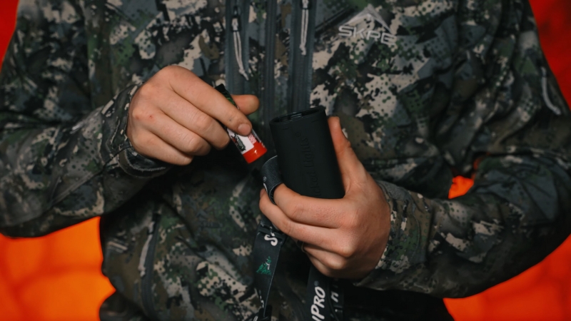 A Person Inserts a Battery Into a Hunting Headlamp