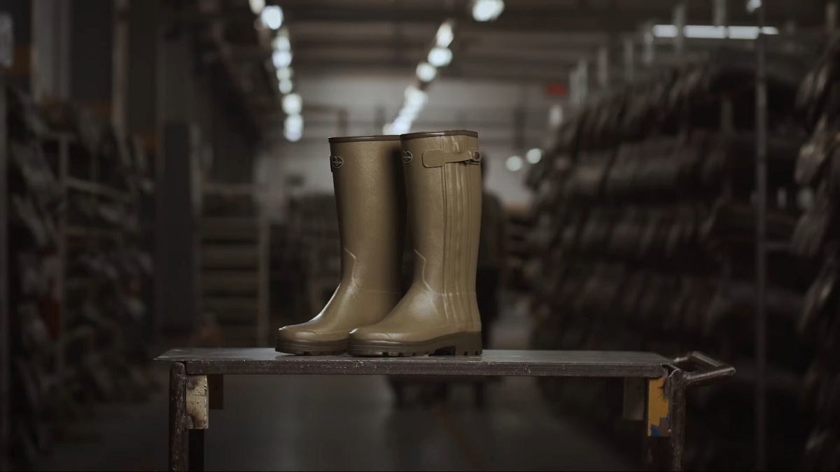 A pair of tall rubber boots placed on a workbench