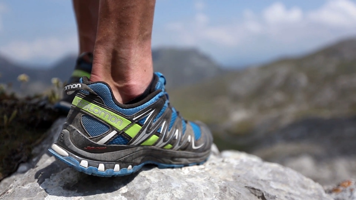 Trail running shoe on a rocky mountain edge