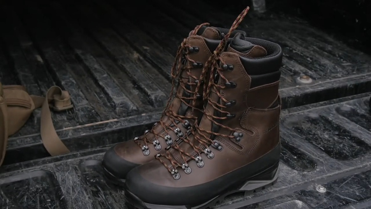 Sturdy brown leather boots with thick laces resting in the back of a rugged truck bed