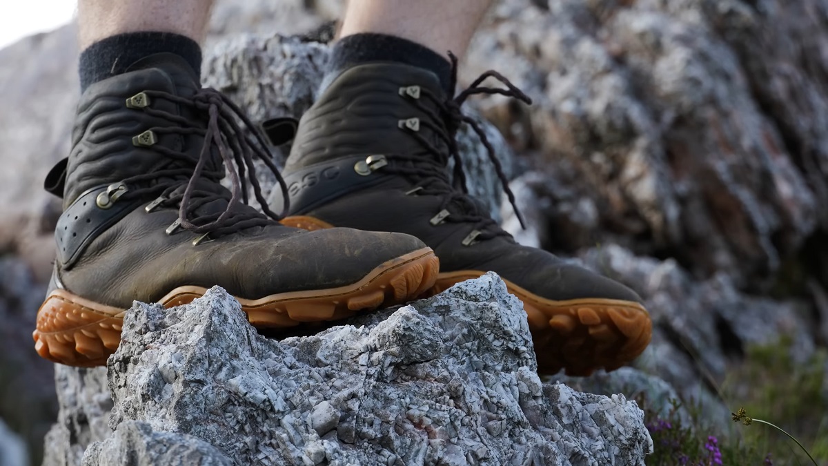 Worn hunting boots standing on jagged rocks